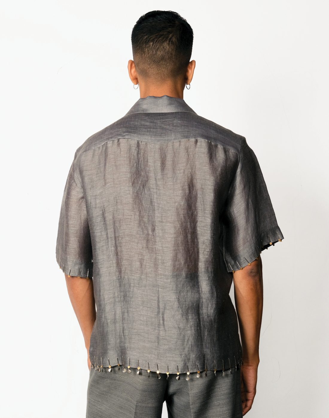 Grey silk-linen half-sleeved shirt with two-tone brass bead embroidery on hems by Taarini Anand back