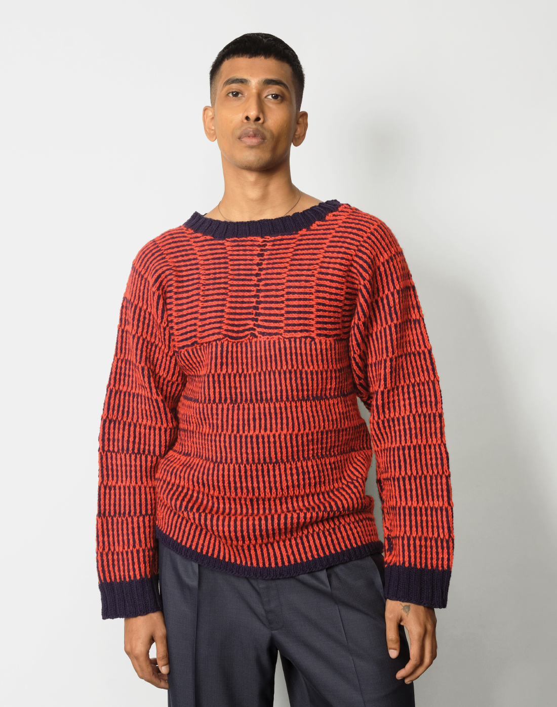 front view red and navy striped kimono-cut sweater with a boat neckline and wide leg navy trousers.