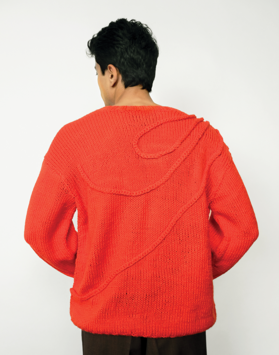 Taarini Anand bright red sweater, oversized hand-knit with organic crochet-cord swirl design
