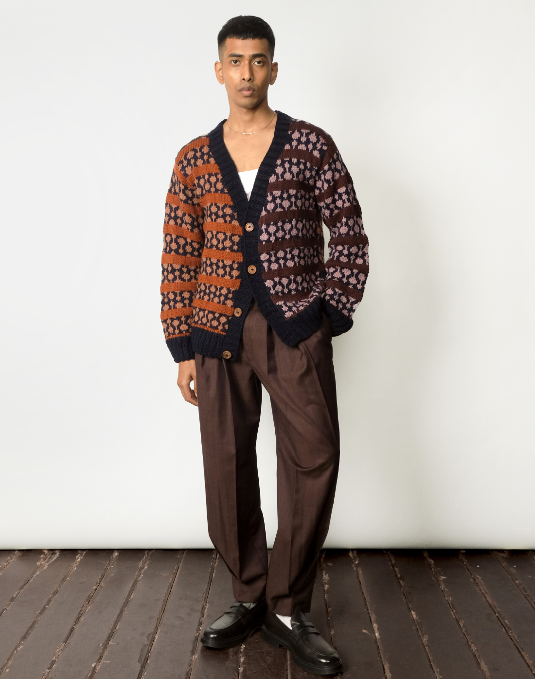 Oversized hand-knit wool cardigan with jacquard logo and contrasting warm & cool tones by Taarini Anand front