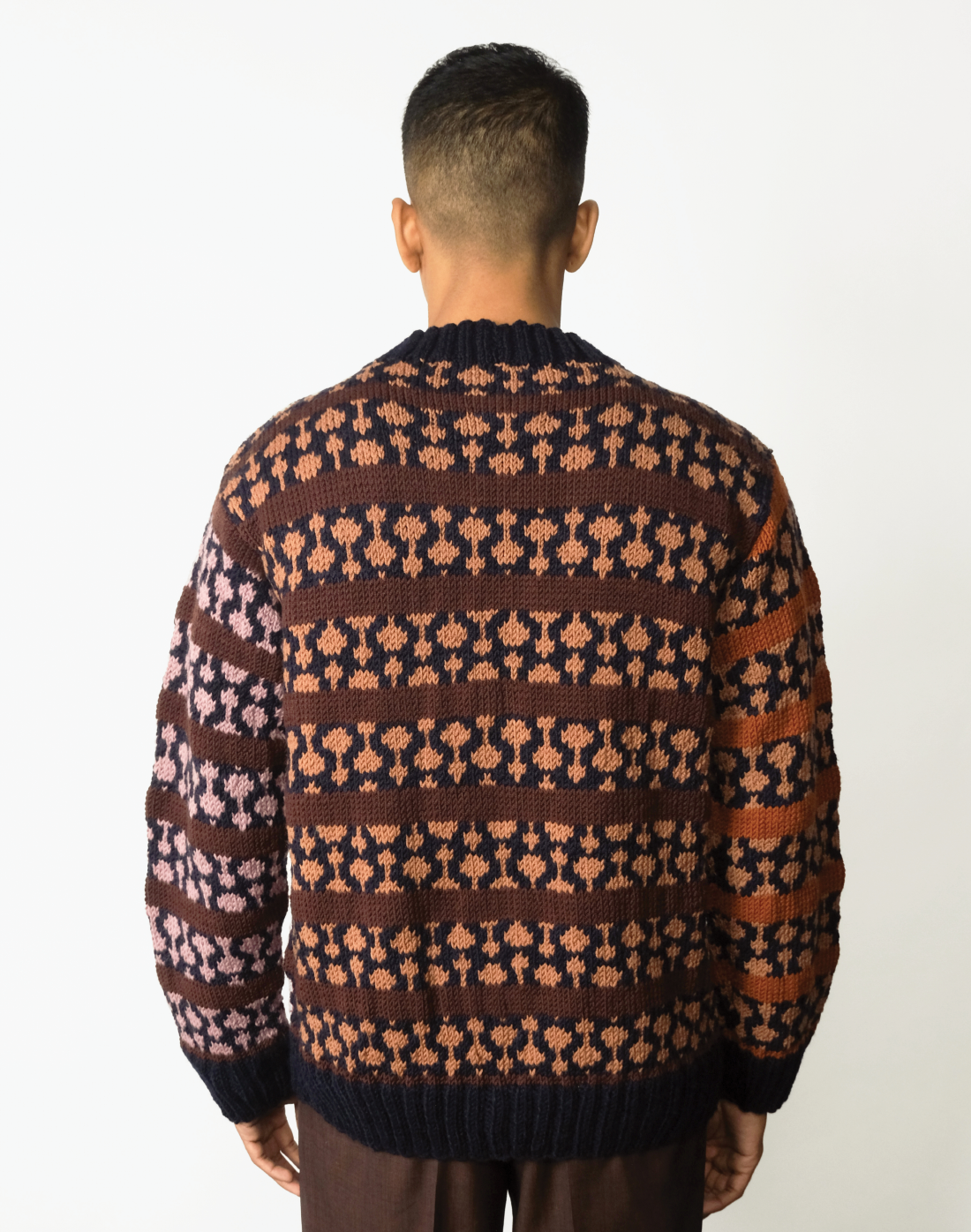 Oversized hand-knit wool cardigan with jacquard logo and contrasting warm & cool tones by Taarini Anand back