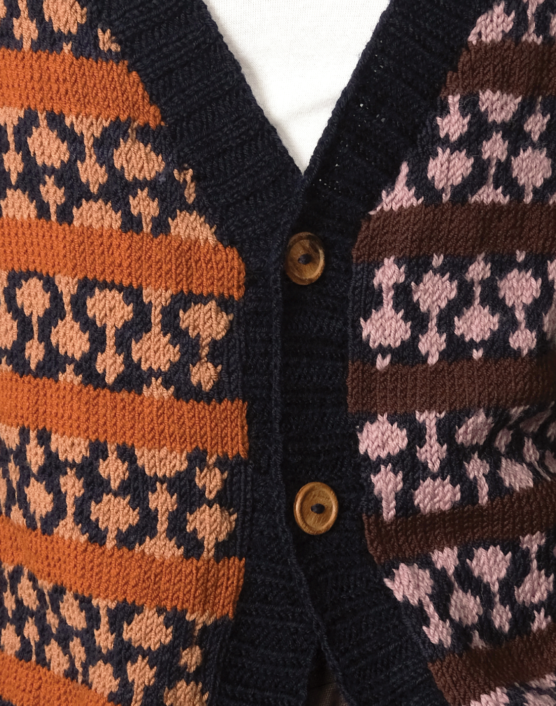 Oversized hand-knit wool cardigan with jacquard logo and contrasting warm & cool tones by Taarini Anand close up