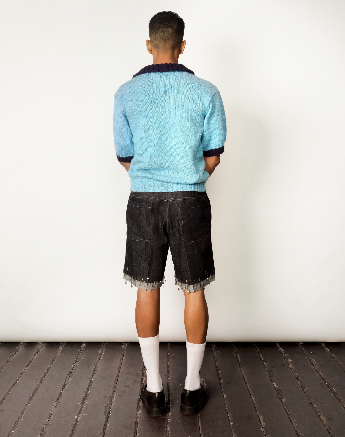 back view Hand-knit sky-blue wool polo sweater with contrast navy collar by Taarini Anand