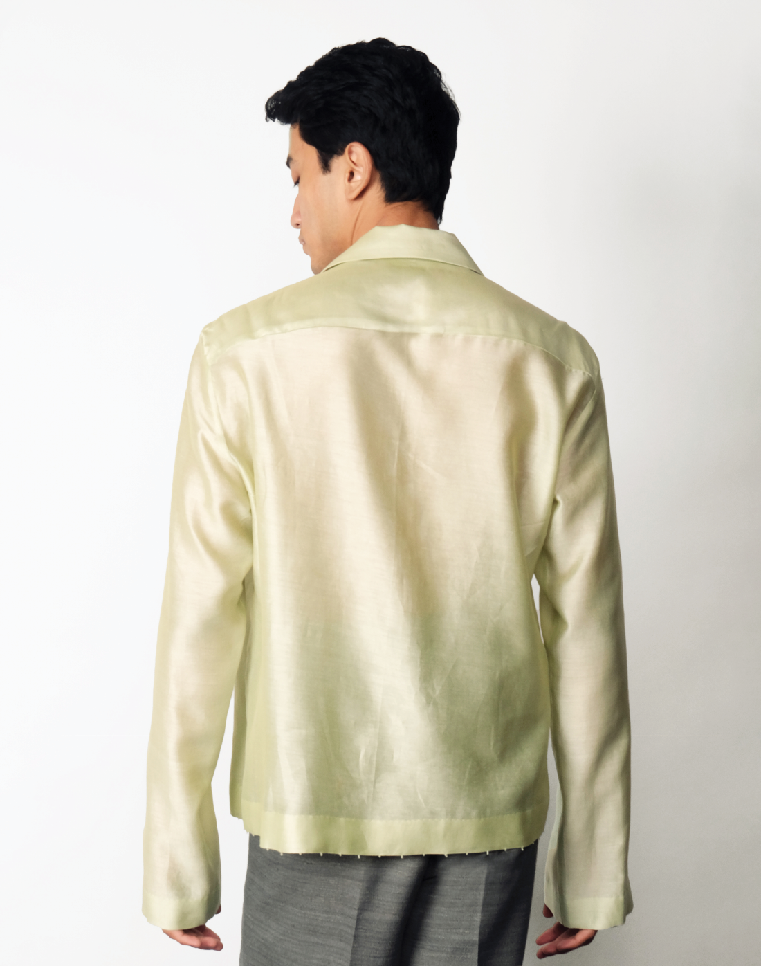 Pale green relaxed Chanderi silk shirt featuring hand embroidered logo-inspired pocket and glass bead trim by Taarini Anand back