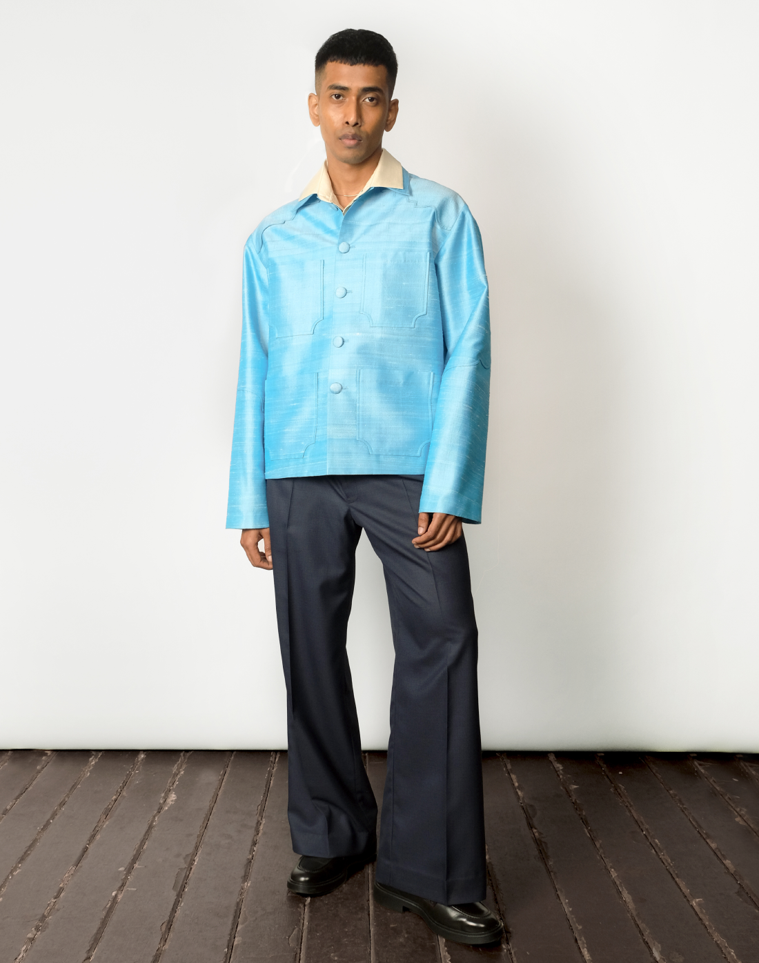 Sky blue raw silk jacket with dropped shoulders, arch-shaped yokes, and four patch pockets