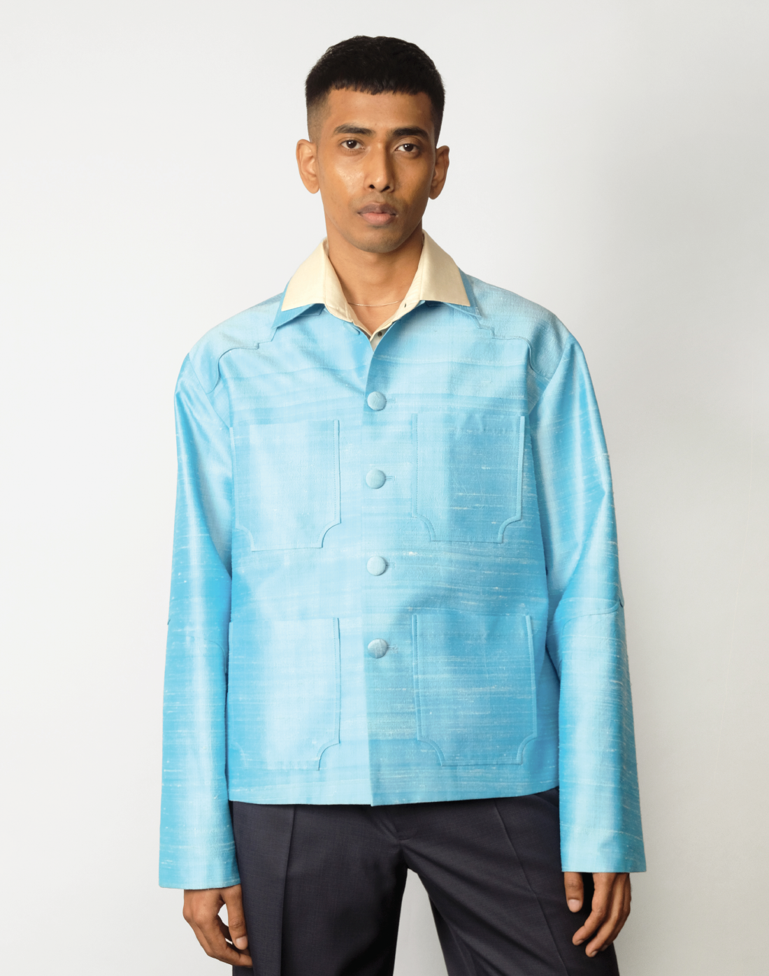 Sky blue raw silk jacket with dropped shoulders, arch-shaped yokes, and four patch pockets front